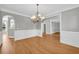 Well-lit dining room showcases hardwood floors, stylish chandelier and detailed wall trim throughout the room at 3641 Carriage Glen Way, Dacula, GA 30019