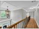 Bright hallway showcasing hardwood floors, detailed trim, and a decorative chandelier at 3641 Carriage Glen Way, Dacula, GA 30019