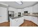 Modern kitchen boasts stainless steel appliances, white cabinetry, granite counters, and a center island at 3641 Carriage Glen Way, Dacula, GA 30019