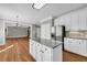 Open kitchen view featuring a granite island, stainless steel appliances, and hardwood floors at 3641 Carriage Glen Way, Dacula, GA 30019