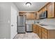 Compact kitchenette equipped with stainless steel appliances, wooden cabinets, and tile flooring at 3641 Carriage Glen Way, Dacula, GA 30019