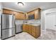 Functional kitchenette with stainless steel appliances, wooden cabinets, and tiled floor at 3641 Carriage Glen Way, Dacula, GA 30019