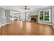 Bright living room with hardwood floors, a stone fireplace, and views into the modern kitchen area at 3641 Carriage Glen Way, Dacula, GA 30019