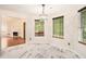Sunlit dining area with marble floors, stylish lighting, and serene wooded view at 4795 Wilkins Station Dr, Decatur, GA 30035