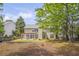 Back of the house with a patio and a large backyard with mature trees at 1465 Laleiah Dr, Cumming, GA 30041