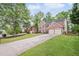 Traditional brick home with a long driveway, green lawn and mature trees at 1465 Laleiah Dr, Cumming, GA 30041