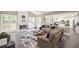 Open-concept living room with fireplace, sofa, rug, and seamless flow to kitchen at 1465 Laleiah Dr, Cumming, GA 30041