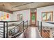 Upper level hallway with hardwood floors, metal railing, and natural light at 640 Glen Iris Ne Dr # 609, Atlanta, GA 30308