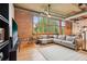 Spacious living room with exposed brick wall, large windows, and cozy sectional sofa at 640 Glen Iris Ne Dr # 609, Atlanta, GA 30308