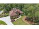 Aerial view of a house with professional landscaping, mature trees, and a long driveway at 6510 Newcastle Way, Cumming, GA 30040