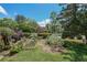 Expansive landscaped backyard featuring a garden, mature trees, and a lush lawn at 6510 Newcastle Way, Cumming, GA 30040