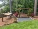 Relaxing backyard featuring a wooden swing, hammock, landscaping and privacy fence at 6510 Newcastle Way, Cumming, GA 30040