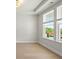 Bright bedroom featuring tray ceiling, large windows, and views of the outdoors at 6944 Melody Ridge Rd, Buford, GA 30518