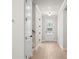Bright hallway with light hardwood floors, white trim, and neutral walls leading to a glass paneled door at 6944 Melody Ridge Rd, Buford, GA 30518