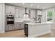 Contemporary kitchen features an island, stainless steel range hood, and gray cabinetry with modern finishes at 6944 Melody Ridge Rd, Buford, GA 30518