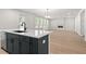 Open-concept kitchen and living room with island, hardwood flooring, and fireplace feature at 6944 Melody Ridge Rd, Buford, GA 30518