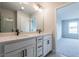 Stylish bathroom with double sinks, white cabinetry, and a view into another room, offering a clean and functional design at 4810 Floydwood Ln, Mableton, GA 30126