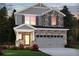 Charming two-story home with stone and siding, showcasing a well-manicured lawn and inviting two-car garage at 5115 Abdulla Dr, Cumming, GA 30041