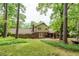 Beautiful backyard showcasing lush lawn, mature trees, and a covered patio, creating a serene outdoor oasis at 7310 Ne Wynhill Ne Dr, Atlanta, GA 30328