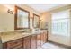 Bright bathroom featuring a granite countertop and double sink vanity with a large window at 7310 Ne Wynhill Ne Dr, Atlanta, GA 30328