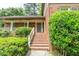 Charming brick home featuring a welcoming front porch with brick stairs and lush landscaping at 7310 Ne Wynhill Ne Dr, Atlanta, GA 30328