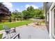Landscaped backyard with a stone patio, seating area, lush lawn, and mature trees at 2407 Boulder Se Rd, Atlanta, GA 30316