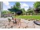 Landscaped backyard with a stone patio, seating area, lush lawn, and mature trees at 2407 Boulder Se Rd, Atlanta, GA 30316