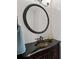 Elegant bathroom vanity with dark wood cabinet, stone countertop, and round mirror at 3253 Strathmore Dr, Duluth, GA 30096