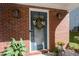 Close-up of the home's front door with a charming wreath, decorative lights, and healthy green plants at 3253 Strathmore Dr, Duluth, GA 30096