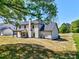 View of home's back exterior featuring covered patio, spacious yard and well maintained lawn at 3132 Rosebud Rd, Loganville, GA 30052