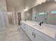 Bright bathroom features double vanity, frameless shower, large mirror, modern fixtures and tile floor at 3132 Rosebud Rd, Loganville, GA 30052