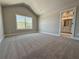 Spacious carpeted bedroom with a large window and bathroom entrance at 3132 Rosebud Rd, Loganville, GA 30052