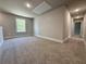Spacious bonus room features neutral color, plush carpet, natural light and easy access to hallway at 3132 Rosebud Rd, Loganville, GA 30052