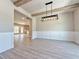 Dining room with wood beam ceiling, modern light fixture and views into the kitchen and living spaces at 3132 Rosebud Rd, Loganville, GA 30052