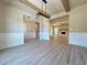 Open dining room with wood beam ceiling, wainscoting, modern light fixture and view into the living room at 3132 Rosebud Rd, Loganville, GA 30052
