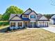 Inviting new construction home featuring a well-maintained lawn and charming architectural details at 3132 Rosebud Rd, Loganville, GA 30052