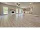 Spacious living room featuring a modern fireplace, ceiling fan, large windows, and a view into the kitchen at 3132 Rosebud Rd, Loganville, GA 30052