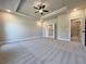 Spacious main bedroom featuring carpet floors, tray ceiling, ceiling fan, and two entrances to the main bathroom at 3132 Rosebud Rd, Loganville, GA 30052
