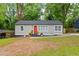 Charming single-story home with a fresh gray exterior, bright orange door, and well-maintained landscaping at 3566 Orchard Dr, Decatur, GA 30032