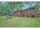 Brick home featuring a spacious backyard with mature trees and lush lawn at 4807 Kenilworth Dr, Stone Mountain, GA 30083
