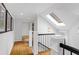 Bright hallway with skylight, hardwood floors, decorative railing, and stylish artwork at 171 Westminster Ne Dr, Atlanta, GA 30309