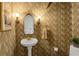 Charming powder room with decorative wallpaper, pedestal sink, and sconce lighting at 171 Westminster Ne Dr, Atlanta, GA 30309