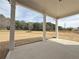 Covered patio with white columns and view of the backyard and surrounding trees at 3154 Rosebud Rd, Loganville, GA 30052