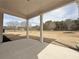 Spacious backyard with a covered patio, white columns and a view of the surrounding landscape at 3154 Rosebud Rd, Loganville, GA 30052