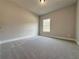 Neutral bedroom featuring plush carpeting and a bright window at 3154 Rosebud Rd, Loganville, GA 30052