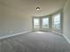 Bright bedroom featuring plush carpeting and multiple windows at 3154 Rosebud Rd, Loganville, GA 30052