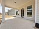 Covered patio with concrete flooring, white columns, and large windows looking into the home's interior at 3154 Rosebud Rd, Loganville, GA 30052
