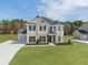 Beautiful two-story home with a well-manicured lawn, black shutters, and a long driveway at 3154 Rosebud Rd, Loganville, GA 30052