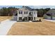 New construction home with light gray brick, shutters, manicured landscaping, and a side entry garage at 3154 Rosebud Rd, Loganville, GA 30052