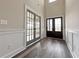 Elegant foyer with stylish wood-look floors, a wainscotting, and double glass paneled doors at 3154 Rosebud Rd, Loganville, GA 30052